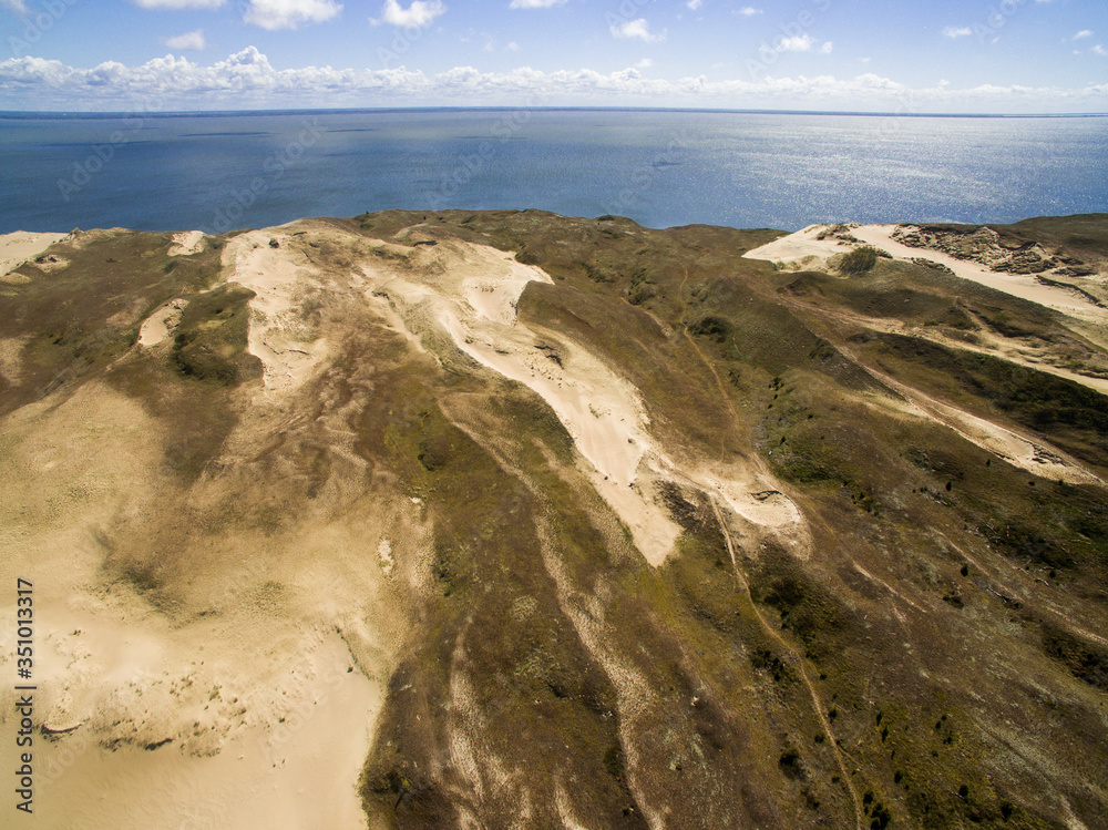 Aerial view with dunes, forest and sea in Curonian spit on a sunny day photographed with a drone. The Curonian Spit lagoon. Gray Dunes, Dead Dunes. Nida, Neringa, Juodkrante, Preila, Pervalka