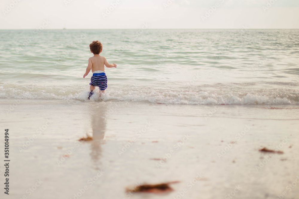 toddler playing on the beach running to the water of marco island beach in south west florida toddler playing on the beach running to the water of marco island beach in south west florida