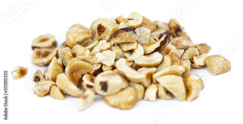 Freshly chopped Hazelnuts isolated on white background (close up; selective focus)