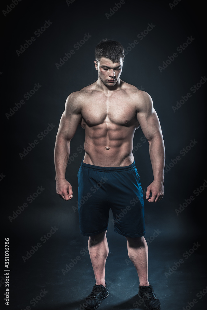 Sexy young athlete posing on a black background in the Studio. Fitness, bodybuilding Sexy young athlete posing on a black background in the Studio. Fitness, bodybuilding