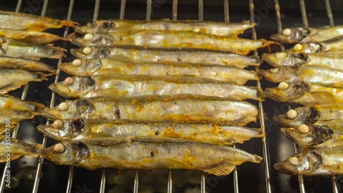 Time lapse video of cooking a fish capelin on grille in oven photo