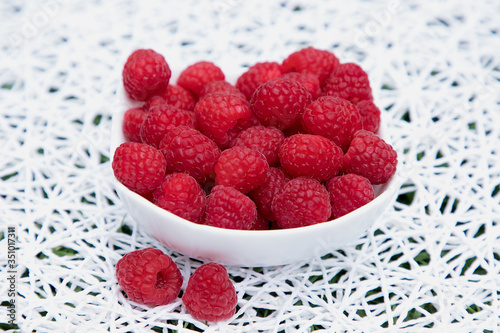 fresh red raspberries on a white patterned background