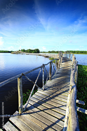 Long wooden walkway connecting to island at Nong Yai Development Project Chumphon Thailand 