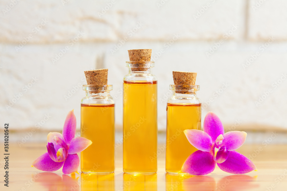 Essence of orchid flowers on table in beautiful glass jar Essence of orchid flowers on table in beautiful glass jar