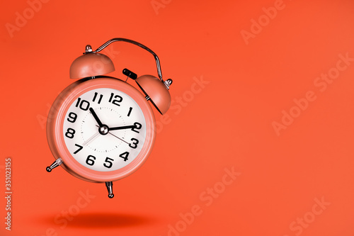 orange alarm clock on orange background