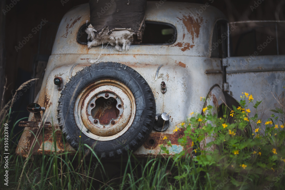a rusty, broken-down white car with a spare wheel a rusty, broken-down white car with a spare wheel