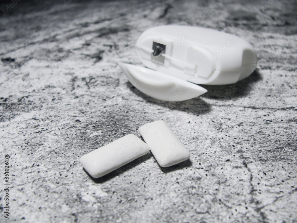 two chewing gum on an open white dental floss background and on a granite background two chewing gum on an open white dental floss background and on a granite background