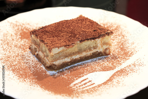 Tiramisu cake dessert with cocoa on the plate
