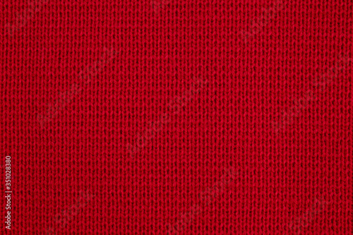Texture of knitted wool fabric close-up. Red knitted background.The texture of the red wool knitted fabric.