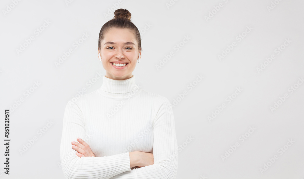 Banner of young woman looking happily at camera, holding arms crossed, comfident about her studies and business, isolated on gray background, copy space on right Banner of young woman looking happily at camera, holding arms crossed, comfident about her studies and business, isolated on gray background, copy space on right
