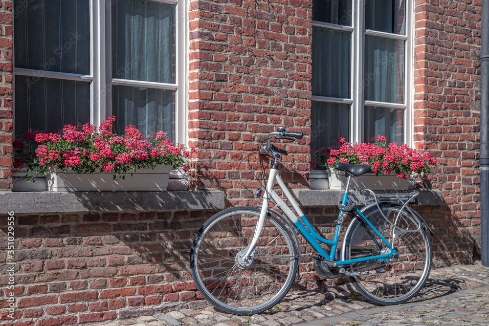 The typical Flemish view of the bicycle near old stone house
