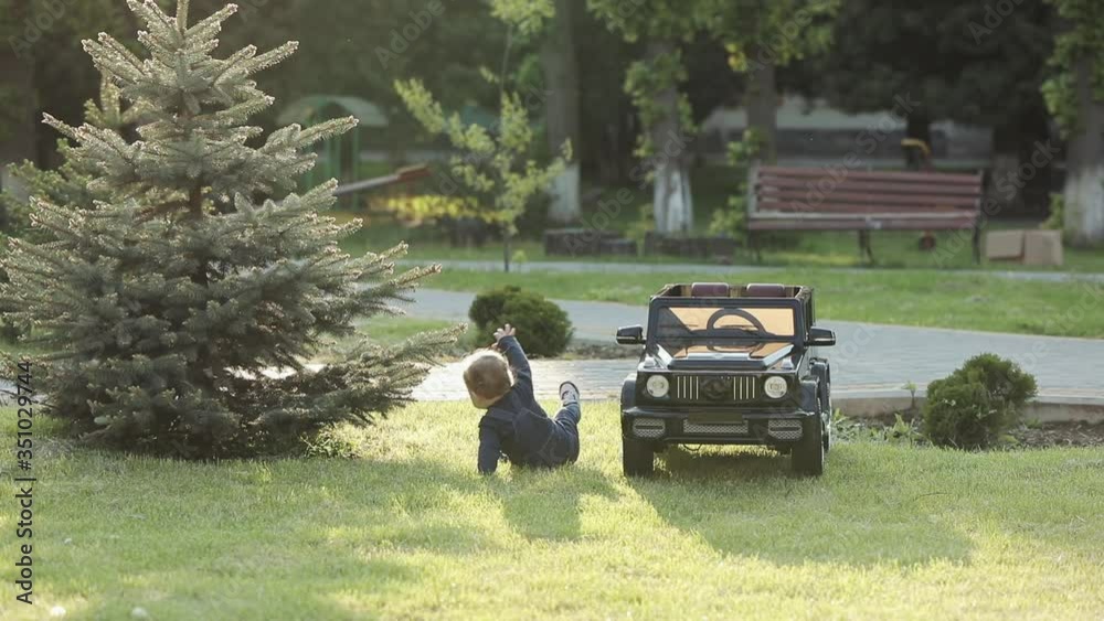 Lovely baby child learning to walk in nature, determined blond boy falling down and rising up, stepping on green grass, development process. Lovely baby child learning to walk in nature, determined blond boy falling down and rising up, stepping on green grass, development process.