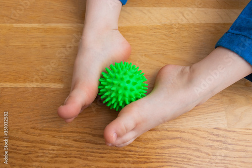 Children s feet with a massage ball  child health concept