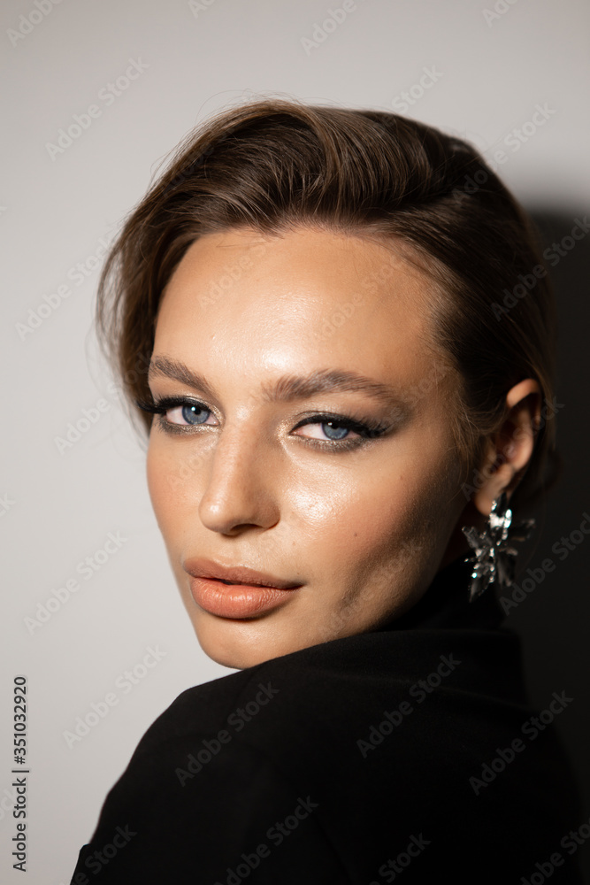 Naklejka premium Portrait of a beautiful woman with makeup and styling. Blue eyes, fashionable eyebrows and beautiful lips.