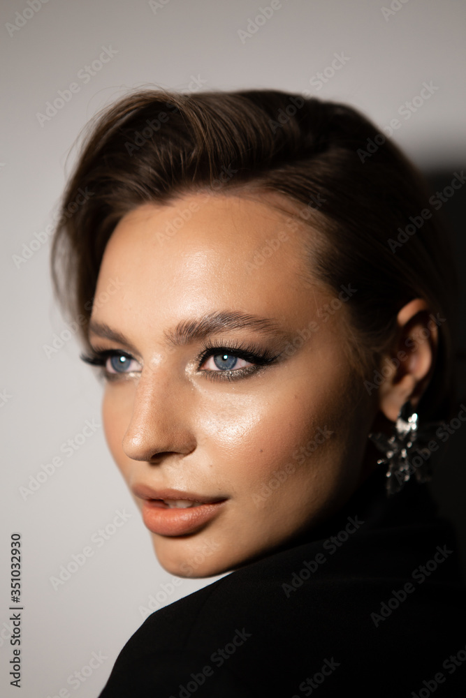 Naklejka premium Portrait of a beautiful woman with makeup and styling. Blue eyes, fashionable eyebrows and beautiful lips.