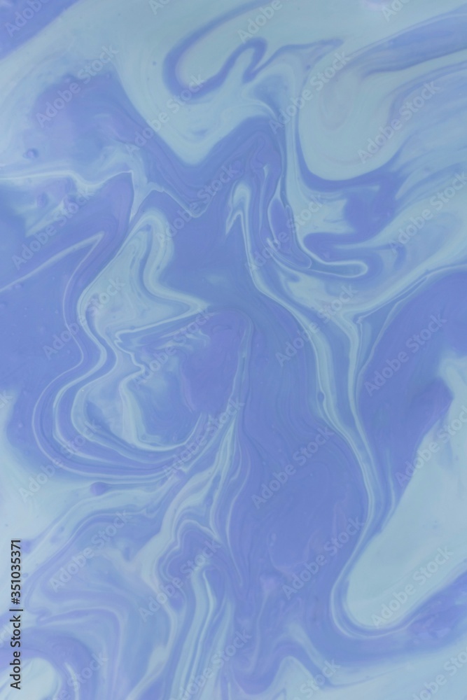 Abstract background of mixed shades of blue nail polish with a marble pattern. Creative background colorful blue liquid paint