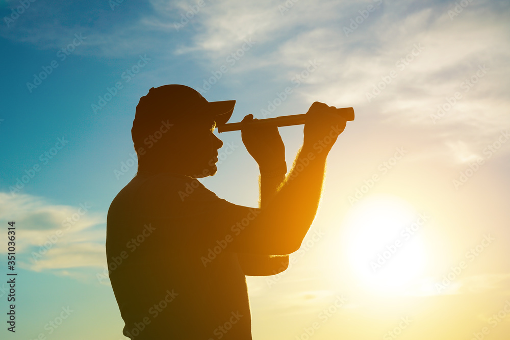 Ταπετσαρία A silhouette of a man looking at using a monocular telescope against a dramatic sky at sunset