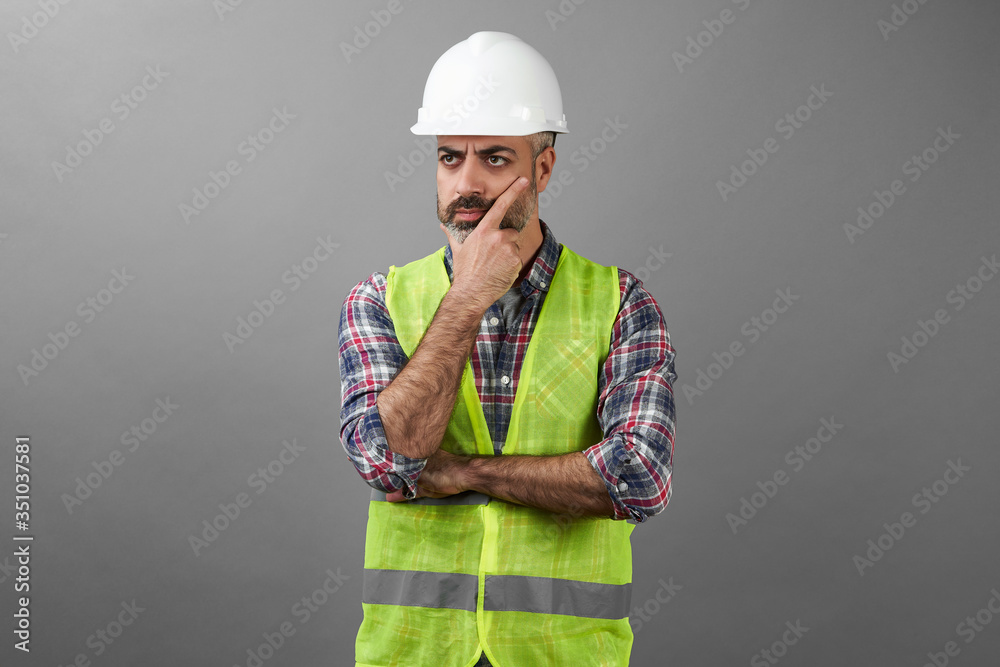 Bearded repair man standing with hands crossed on grey background