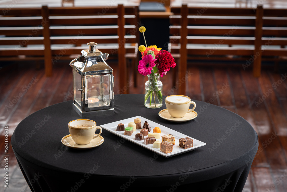 Different chocolate sweets with coffee served on an standing table with maritime details