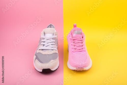 Sneakers lie on a multi-colored pastel surface. Top view. Sport and lifestyle content