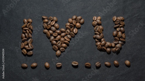 roasted coffee beans on a black background. symbolizes the sign I love you