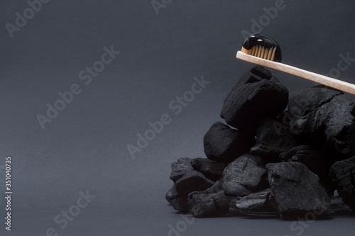 Billede på lærred Natural toothpaste activated charcoal and bamboo toothbrush on black  background