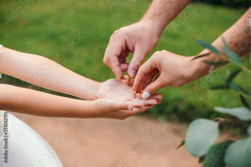 husband and wife take gold wedding rings © sergiokat