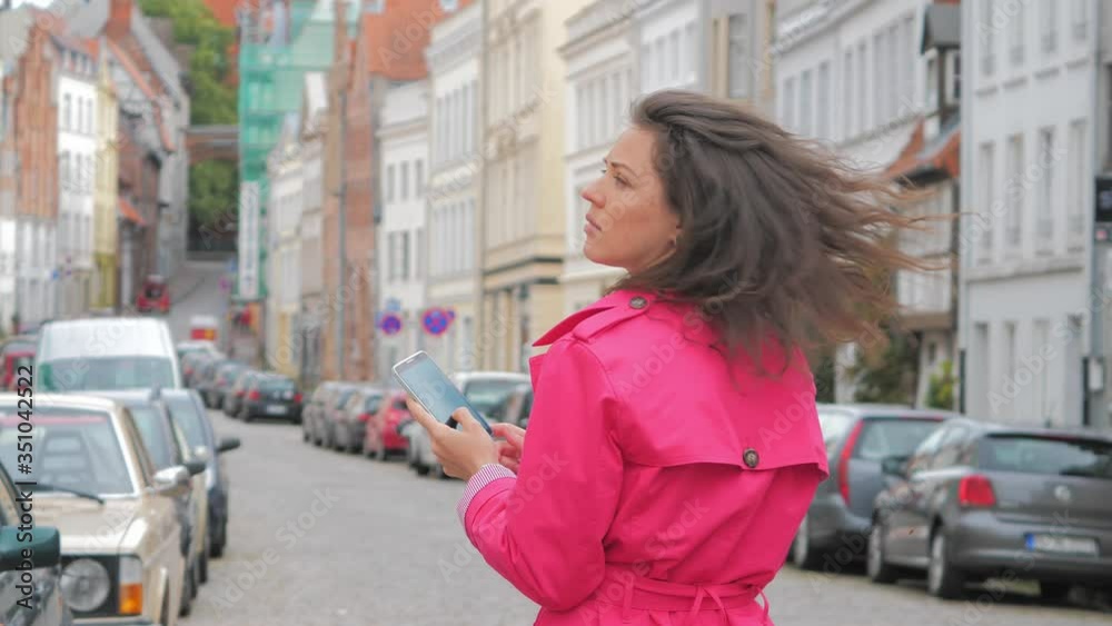 Young woman using application on the mobile phone to find the needed address Young woman using application on the mobile phone to find the needed address