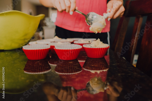 hermanas jóvenes ayudando madre en cocina moderna horneando bizcocho