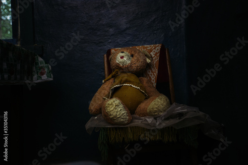 Old Teddy bear sitting in abandoned house