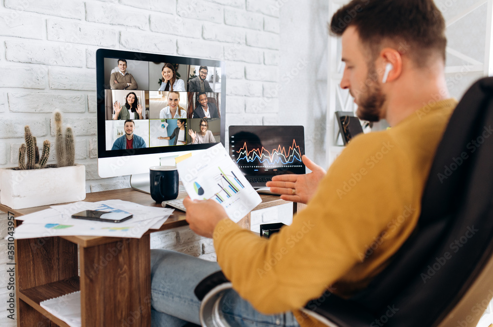 Online business meeting. A young business man communicates by video conference with his business team about a work strategy and plan. Work from home