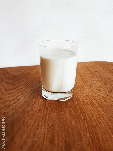 A glass of milk on a wooden kitchen Board.