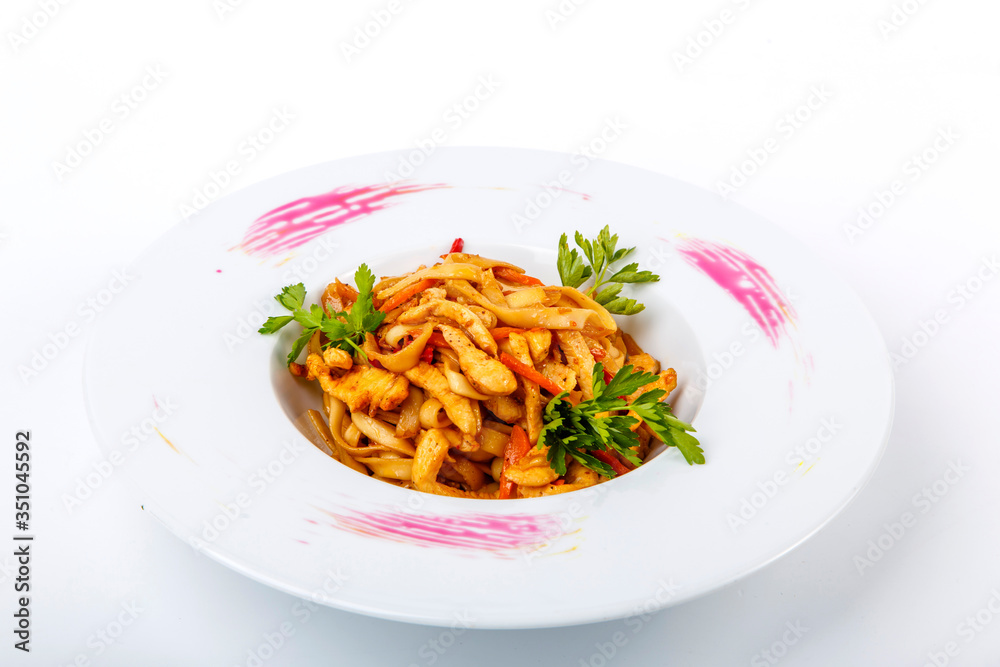 Udon with chicken: Udon Noodles, chicken fillet, zucchini, paprika, carrots, sesame. Plate on a white background. Udon with chicken: Udon Noodles, chicken fillet, zucchini, paprika, carrots, sesame. Plate on a white background.