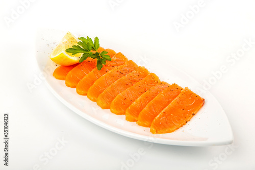 Salted salmon with butter and lemon. Plate on a white background