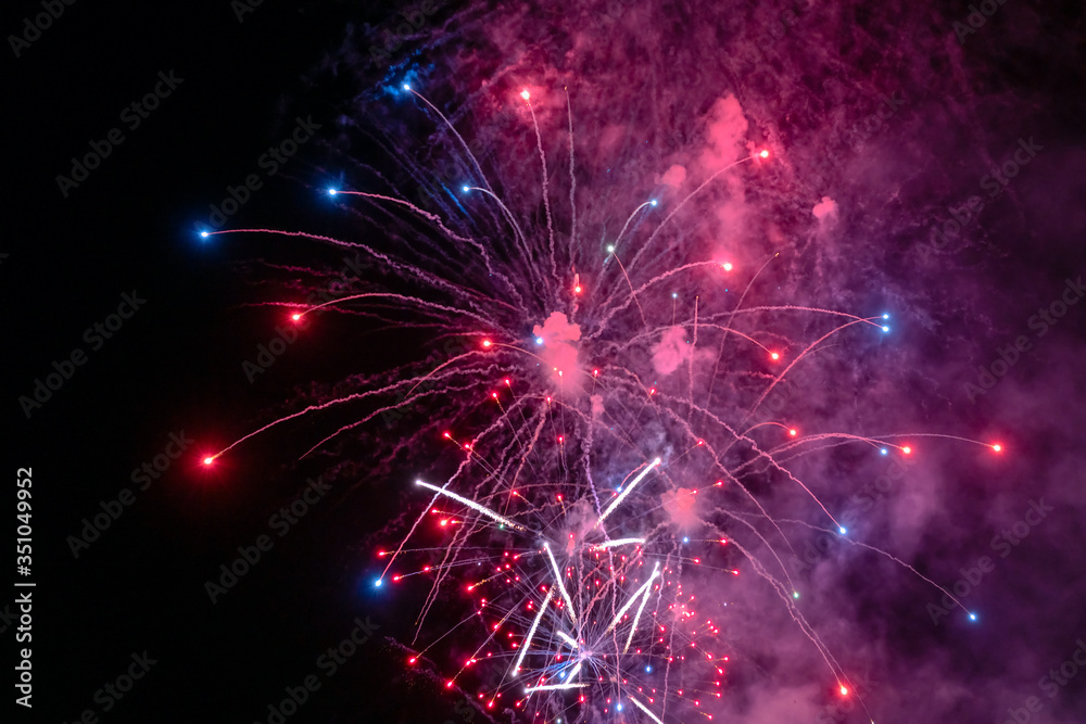 Red and white fireworks with smoke over the black sky. Low key exposure. Red and white fireworks with smoke over the black sky. Low key exposure.