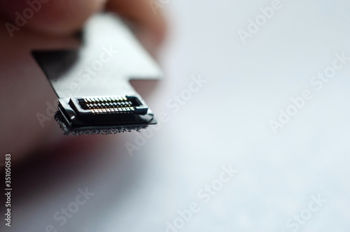 Close-up flat phone jack in hand on a white background.