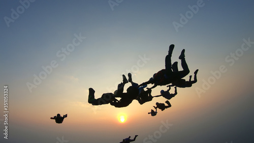 Silhouette of a group of skydivers jumping at the end of the day.
