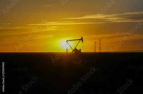 Silhouette Oil pumps at oil field with sunset sky background