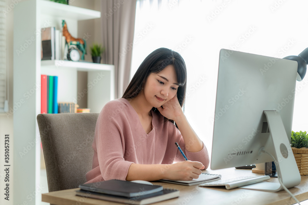 Young asian businesswoman using computer work from home for protect virus and take care of their health from COVID-19. Working at home and social distancing concept. Young asian businesswoman using computer work from home for protect virus and take care of their health from COVID-19. Working at home and social distancing concept.