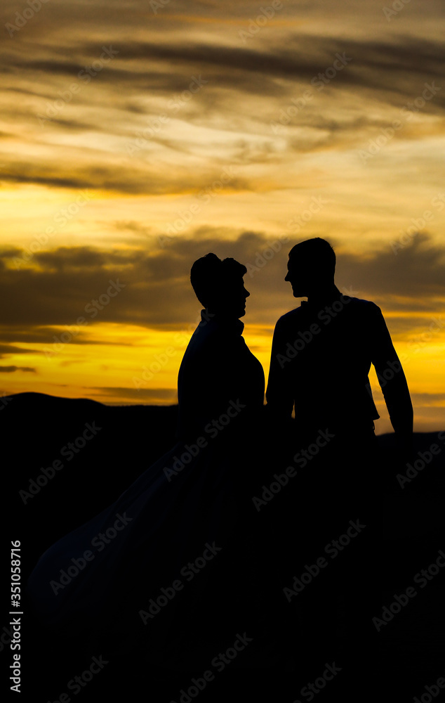 At sunset, a girl and a man. Love look.