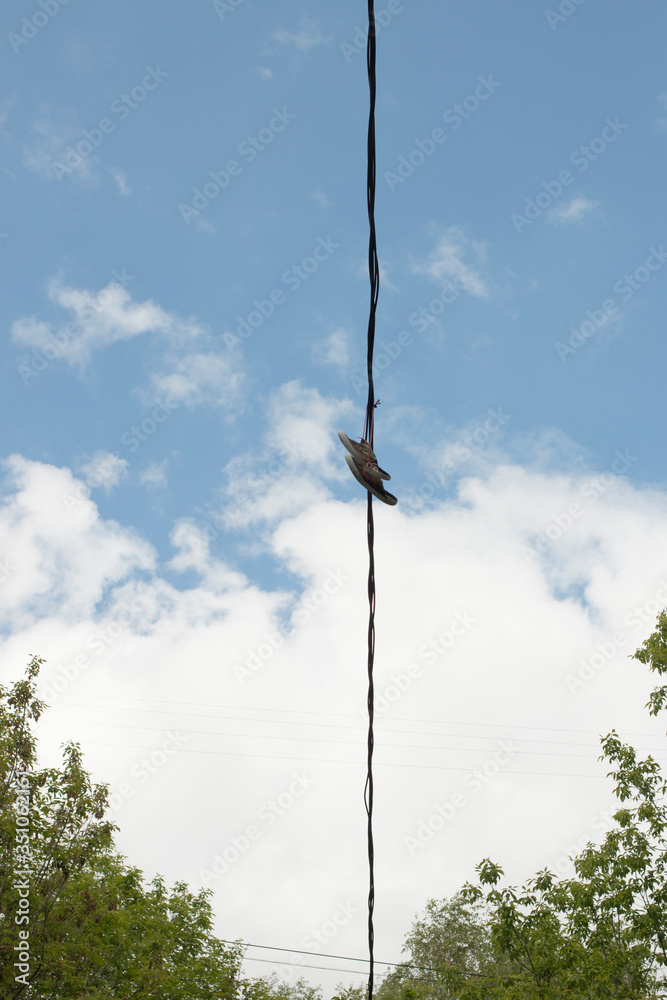 Shoes against the sky. Shoes hanging on electric wires. Shoes against the sky. Shoes hanging on electric wires.