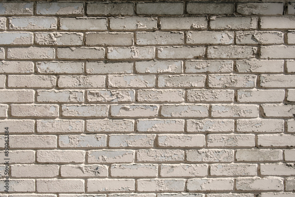 Wall of white brick with peeling off paint outdoors. Background. Wall of white brick with peeling off paint outdoors. Background.