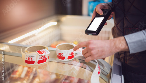 barcode scanner in hand checks the price of products in the supermarket. close-up view