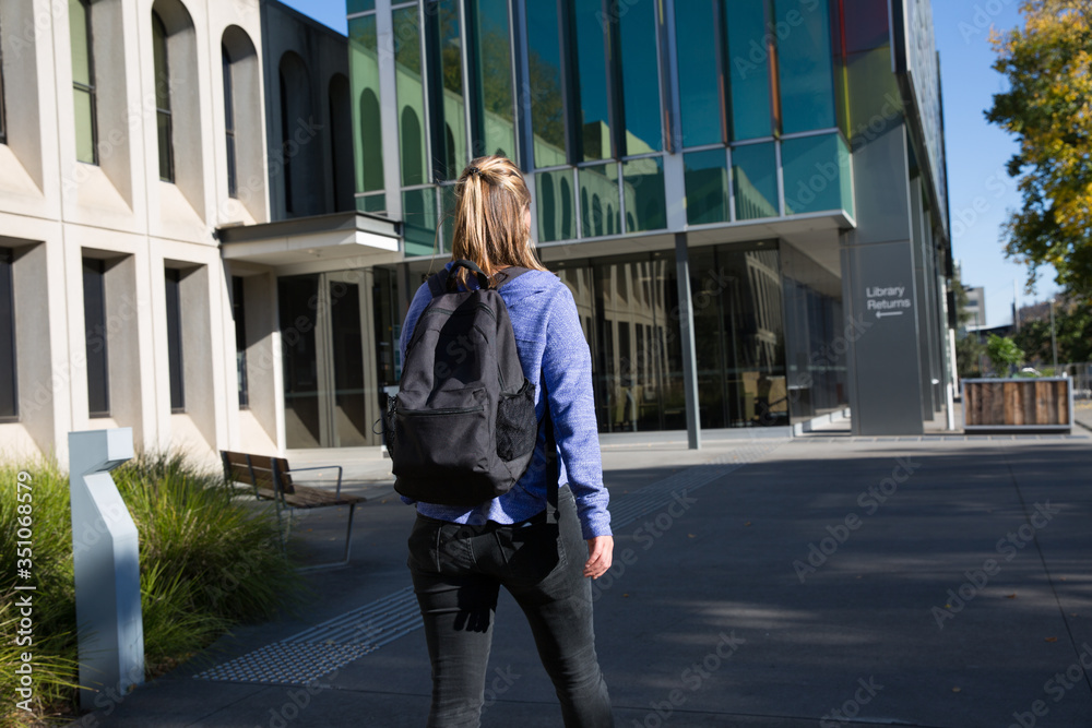 Student Walking Towards the Library Building Student Walking Towards the Library Building