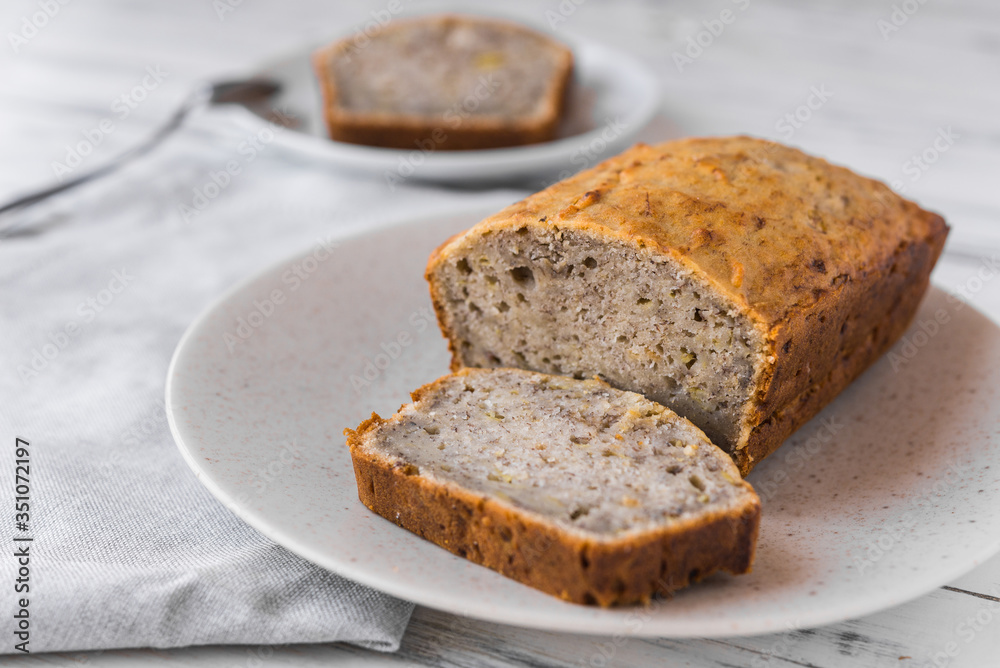 Vegan banana bread loaf cake against white wooden background. Dessert food concept. Vegan banana bread loaf cake against white wooden background. Dessert food concept.