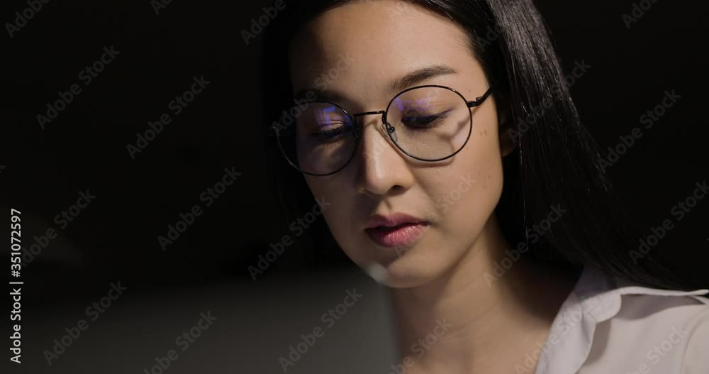 Beautiful asian business woman using computer to online work at dark room. She working with serious face at home. Beautiful asian business woman using computer to online work at dark room. She working with serious face at home.