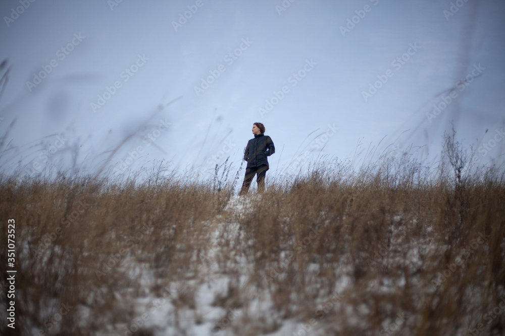 A girl stands in a field in winter. A girl stands in a field in winter.