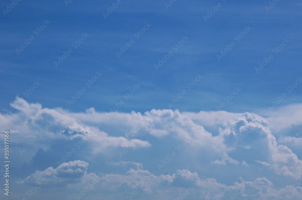 Deep blue skies with white clouds background with space for text, blue cloudy skies texture, dark blue sky wallpaper with with white fully clouds and sunlight