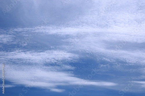 Deep blue skies with white clouds background with space for text, blue cloudy skies texture, dark blue sky wallpaper with with white fully clouds and sunlight