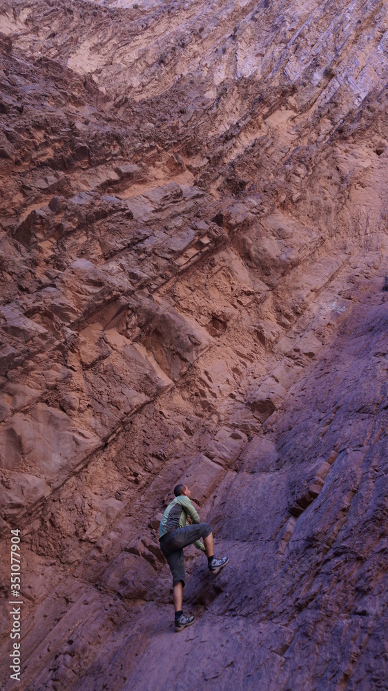 Hombre escalando montaña rocosa